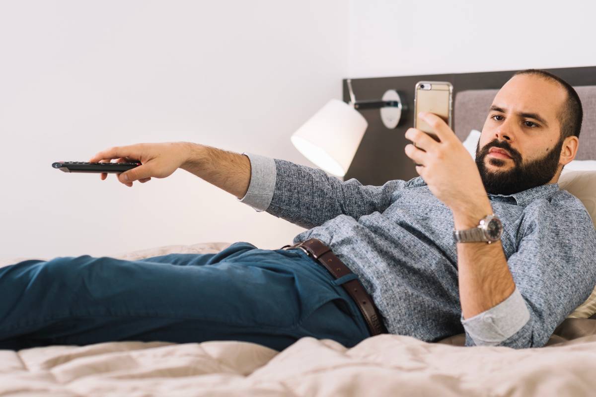 Person streaming IPTV on smart TV and phone